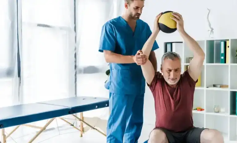 stock photo handsome doctor standing mature man working out fitness ball 0.jpeg